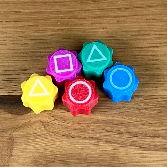 Eine Hand wirft einen Gonggi-Stein in die Luft und greift einen anderen Stein vom Boden